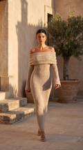 Off-Shoulder Knitted Maxi Dress in apricot, walking through a sunlit stone courtyard